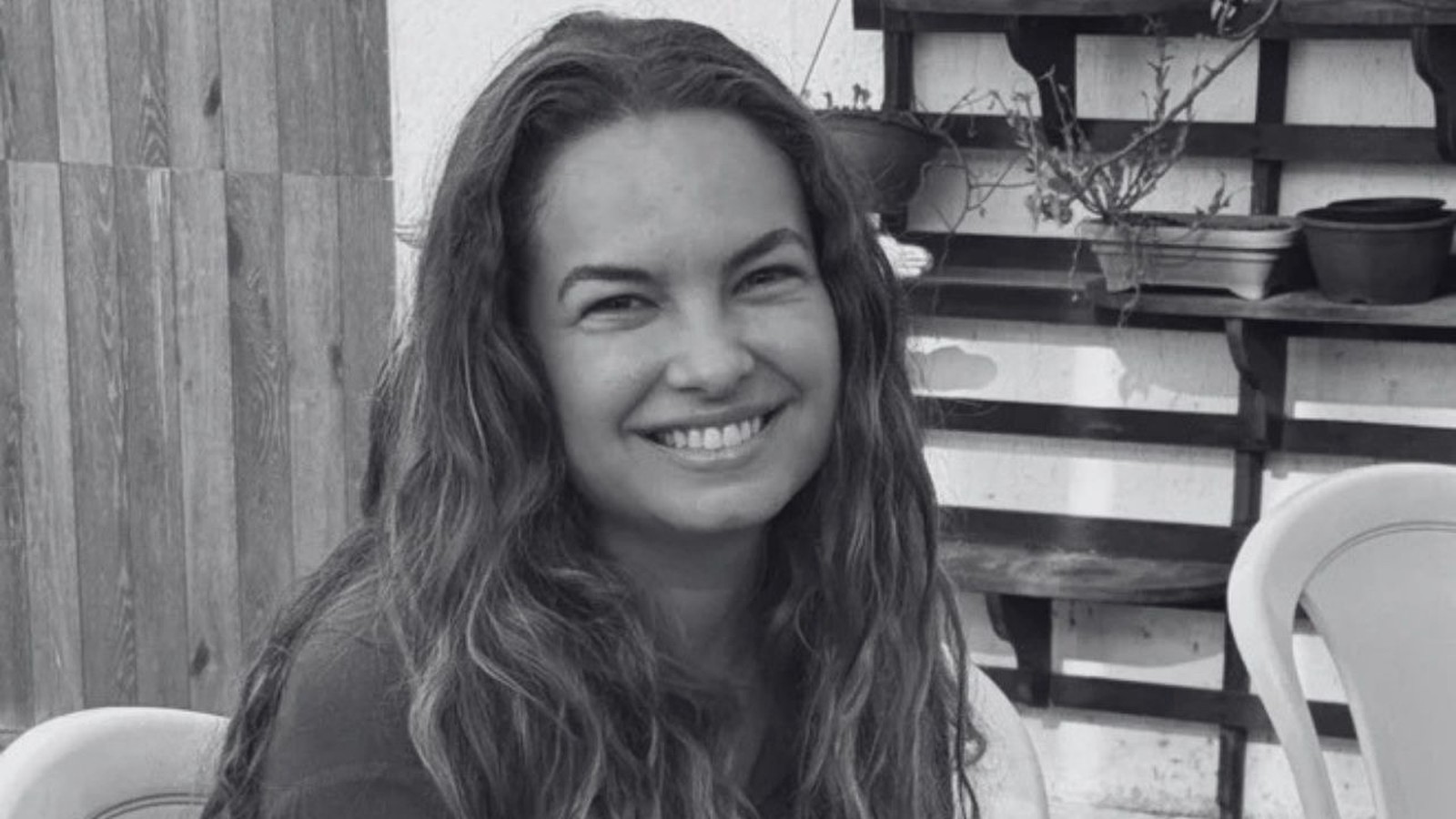 Retrato em preto e branco de Lua Blanco sorrindo, com cabelos longos e ondulados
