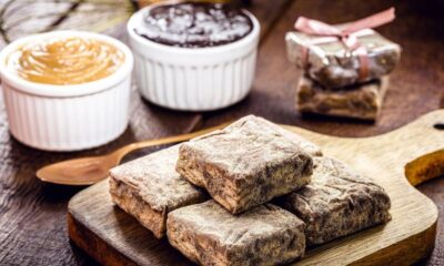 Palha italiana com açúcar em tábua, potes de brigadeiro e doce de leite