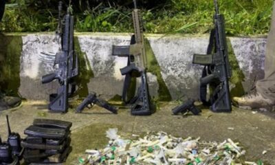 Três fuzis, duas pistolas, carregadores, rádios e drogas embaladas no chão