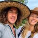 Carles Puyol e Vanesa Lorenzo sorrindo com chapéus de palha em meio à natureza