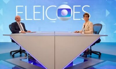 Lula e Renata Lo Prete em estúdio de TV, sentados em mesa, com a inscrição ELEICOES e logo Globo