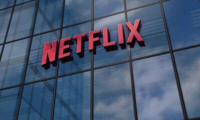 Logotipo vermelho da Netflix em 3D na fachada de vidro de um edifício moderno