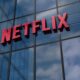 Logotipo vermelho da Netflix em 3D na fachada de vidro de um edifício moderno