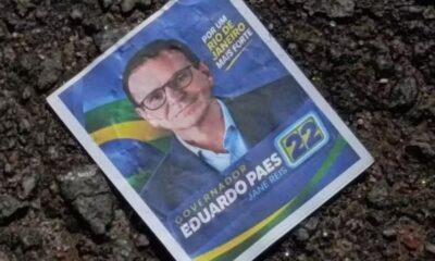 Panfleto político no chão com foto de Eduardo Paes e o número 22