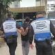 Agentes do Segurança Presente escoltam homem algemado em área urbana
