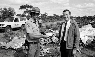 Agente de parque australiano entrega multa a funcionário da NASA perto de destroços da Skylab.