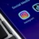 Smartphone screen displays Instagram and TikTok app icons on blue, beside a black keyboard