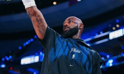 LeBron James com barba e camiseta 'Phila', braço direito tatuado erguido em quadra