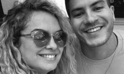 Homem barbudo e mulher de óculos sorrindo em selfie preto e branco