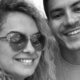 Homem barbudo e mulher de óculos sorrindo em selfie preto e branco