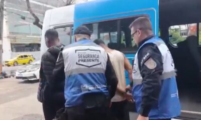 Agentes "Segurança Presente" e "3-BPM" prendem dois homens ao lado de van azul