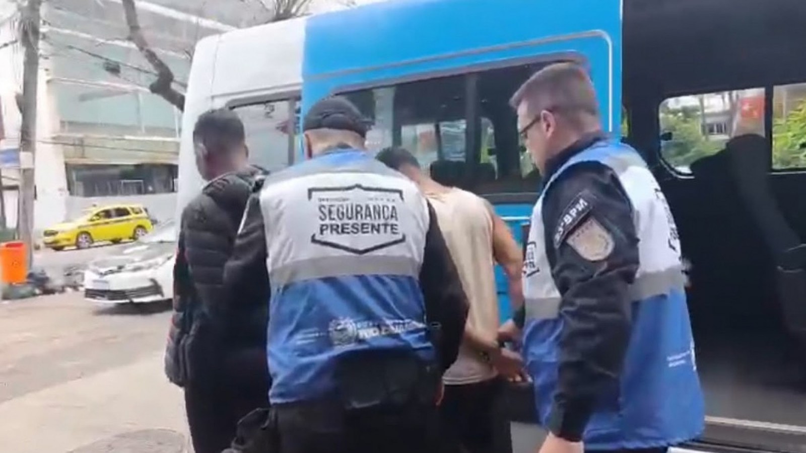 Agentes "Segurança Presente" e "3-BPM" prendem dois homens ao lado de van azul