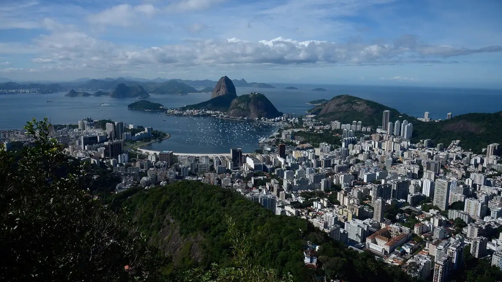 Vista panorâmica do Rio de Janeiro, com Pão de Açúcar, baía com barcos e prédios