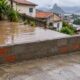 O terreno de baixo deve receber a água que escorre naturalmente, e um muro que bloqueie esse fluxo pode gerar responsabilidade por danos