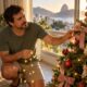 Árvore de Natal colada à janela recebe sol da tarde, e enfeites desbotam enquanto o pisca-pisca esquenta