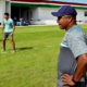 De boné roxo e camisa cinza, Roger Machado observa o treino do Fluminense