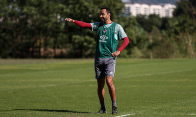 De colete verde, Nenê sorri no treino do Fluminense