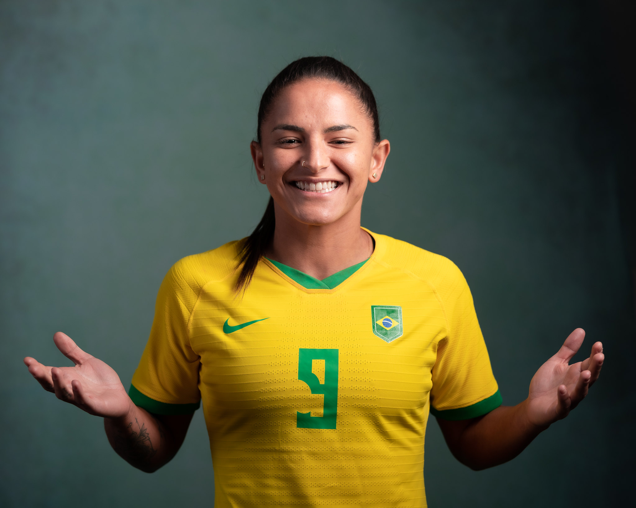 Debinha jogadora da seleção brasileira com a camisa da equipe sorrindo 