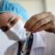 Imagem de uma enfermeira segurando uma seringa