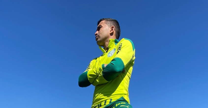 De braços cruzados, Dudu posa para a foto com o casaco verde do Palmeiras