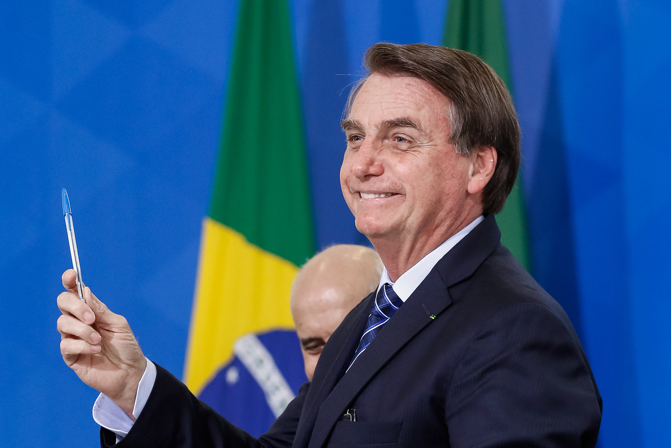 Bolsonaro segura caneta bic na mão