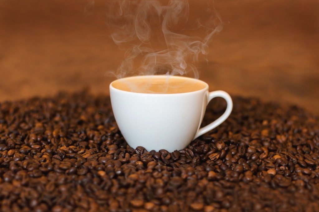 Imagem de um xícara de café sobre grãos