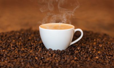Imagem de um xícara de café sobre grãos