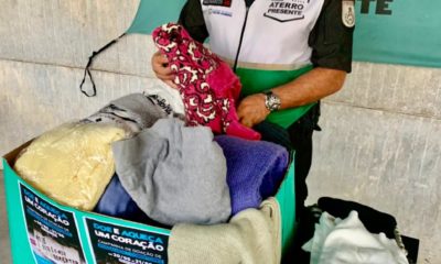 Imagem de um policial separando roupas para doações