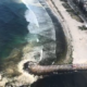 Após rompimento de ecobarreira, gigogas invadem Praia da Barra