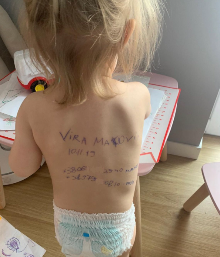 Criança com informações familiares escritas na pele