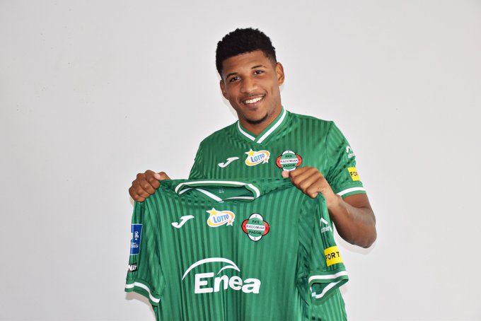 Rhuan segurando a camisa sendo apresentado em time polonês