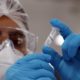 pesquisador analisa frasco com vacina contra a Covid
