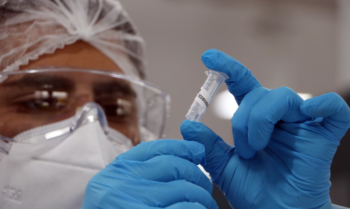 pesquisador analisa frasco com vacina contra a Covid