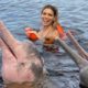 Erika Schneider nada com botos no Rio Negro (Divulgação)