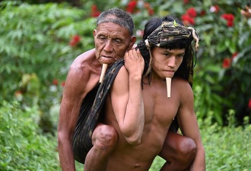 Indígena carrega pai nas costas para tomar vacina da Covid