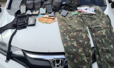 Carro roubado pelos suspeitos com cintos de guarnição, capa de colete à prova de balas e roupas camufladas