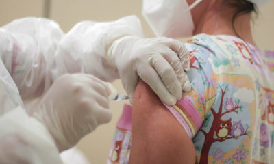 Profissional de saúde aplicando vacina contra a Covid-19
