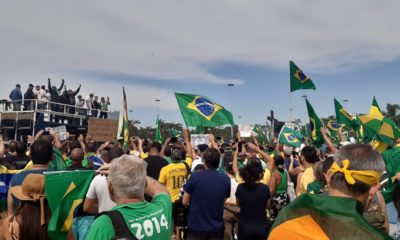 Pessoas com camisa e bandeiras do Brasil em apoio a Bolsonaro