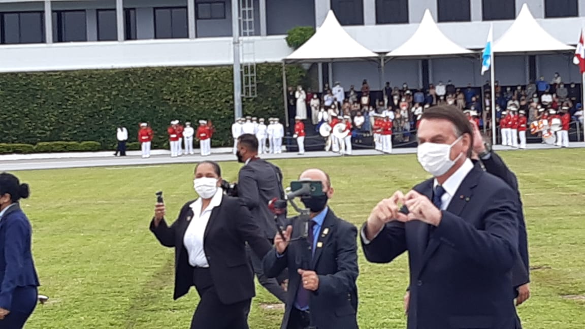 Bolsonaro na Escola Naval fazendo coração para a imprensa