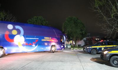 Imagem um ônibus e duas viaturas da PRF