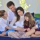 Daniel com a esposa e as filhos no sofá anunciando terceira gravidez