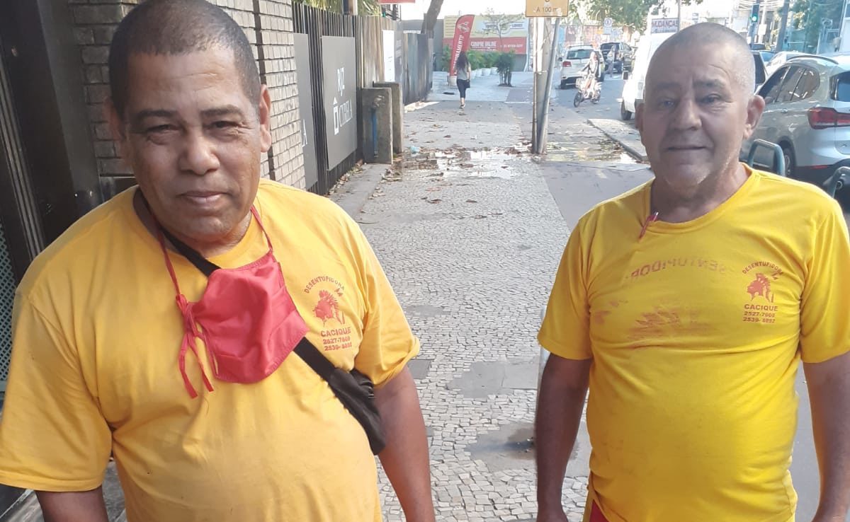 Na imagem, dois homens que encontraram uma sacola com roupas e devolveram para o dono