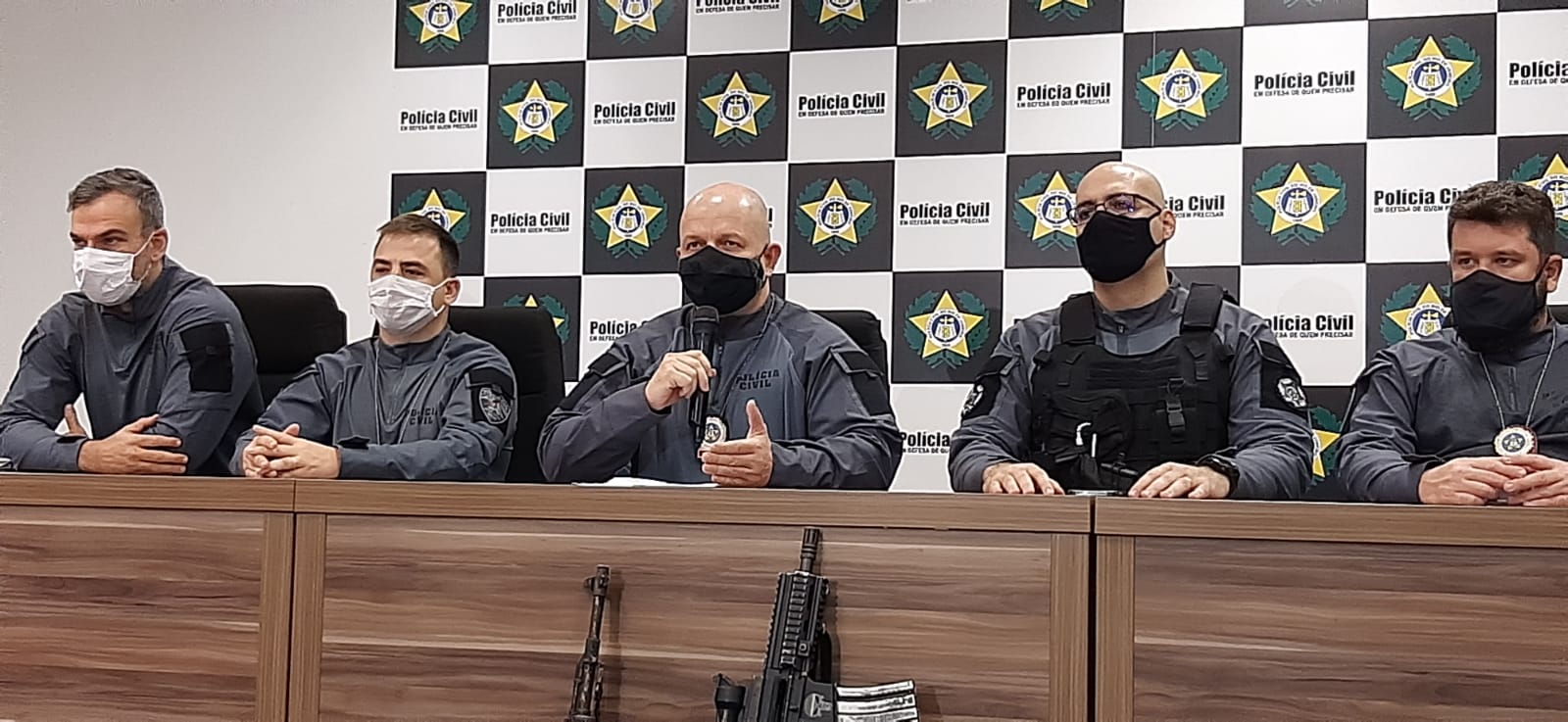 Imagem de quatro policiais civis em uma mesa