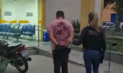 Um dos presos da operação chegando na delegacia