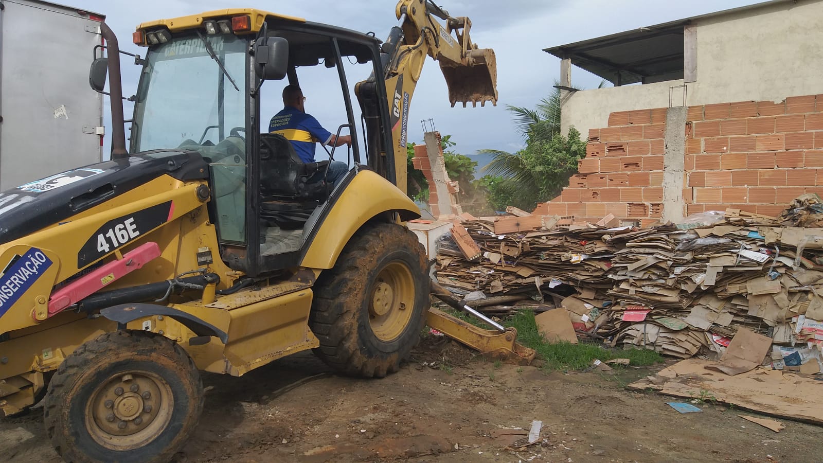 Retroescavadeira da prefeitura demolindo a estrutura