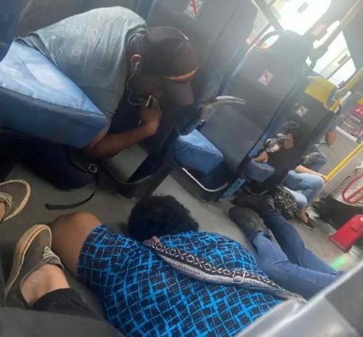 Passageiros se protegem no chão de um ônibus por conta de um tiroteio na Cidade Alta