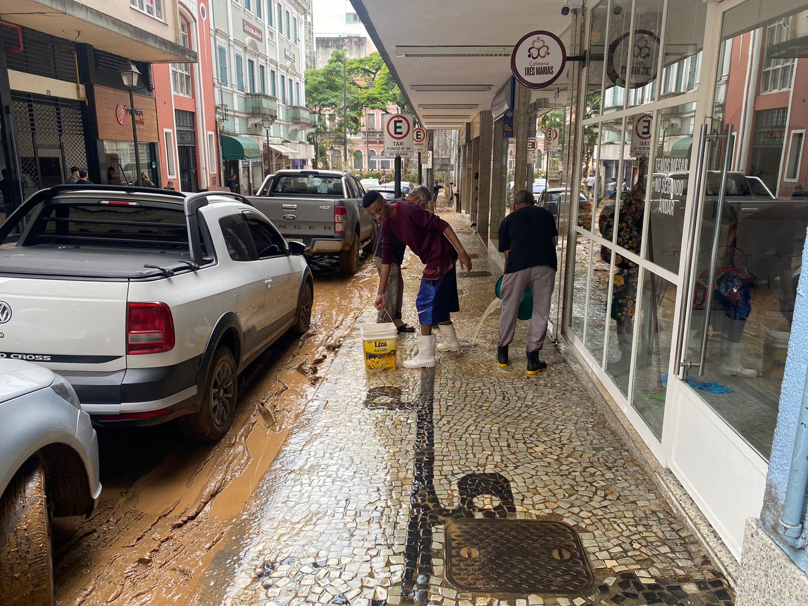 Comerciantes limpam rua em Petrópolis após temporal