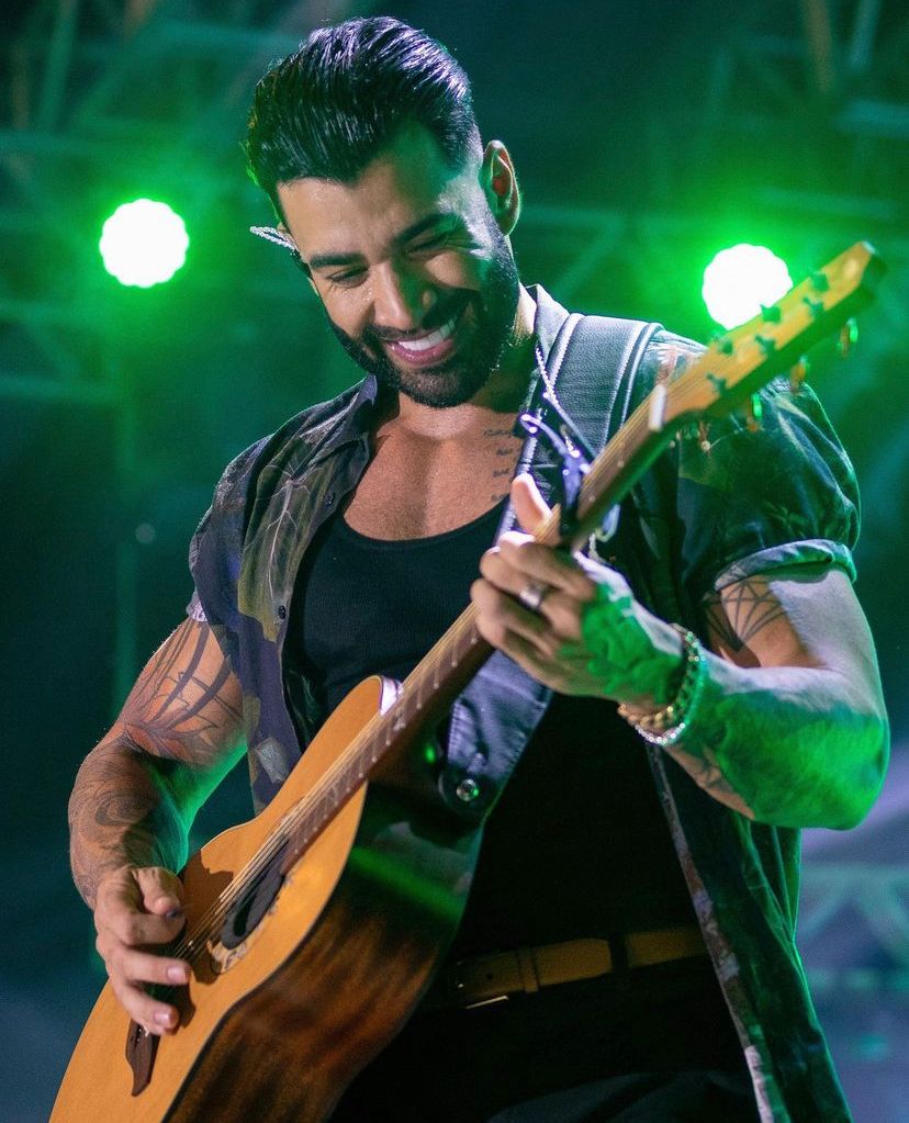 Gusttavo Lima no show tocando violão