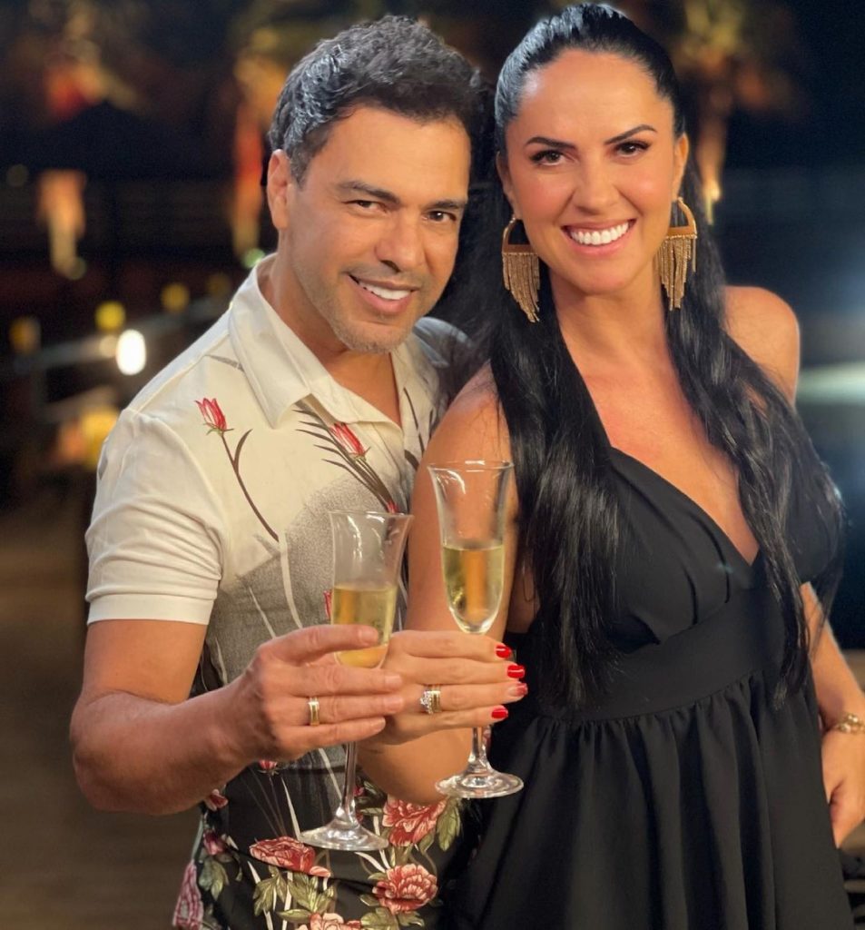 Zezé di Camargo e Graciele Lacerda mostrando aliança de noivado e segurança uma taça de champagne