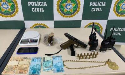 armas, drogas e celulares em cima de uma mesa